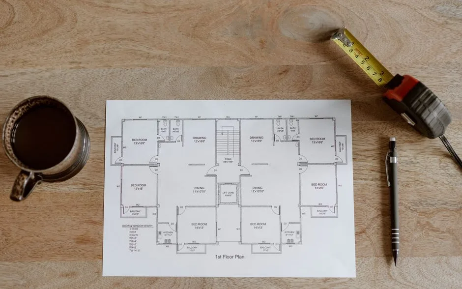 Table de travail avec nuanciers de peinture, mètre ruban et plan de pièce annoté