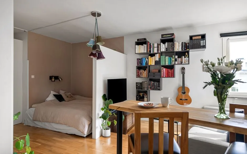 Studio rangé avec des étagères hautes, des caissons bas et un lit surélevé