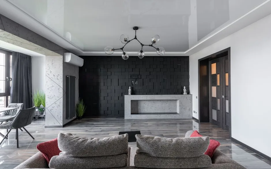 Salon repeint avec un mur du fond en teinte foncée, canapé et tapis clairs
